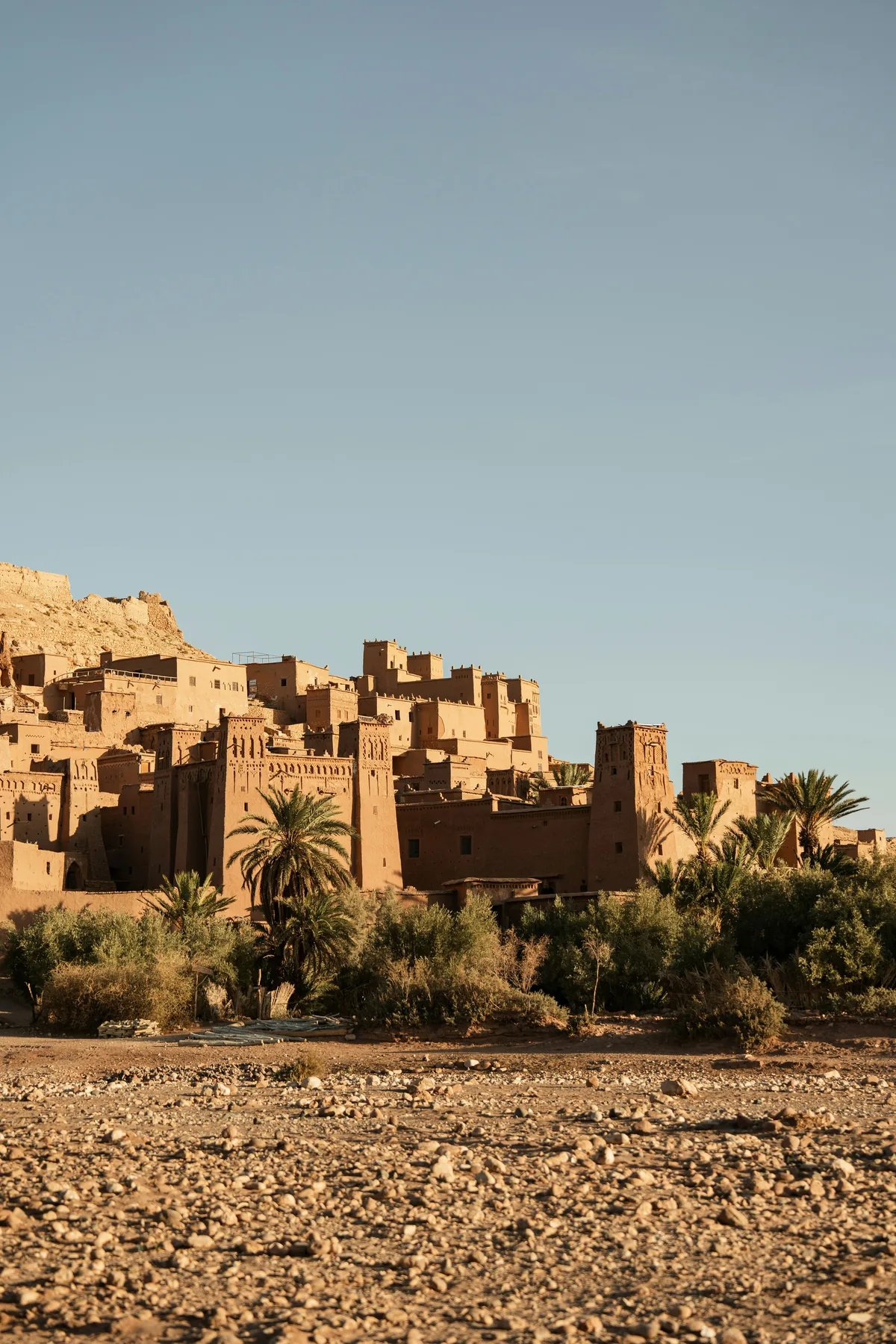 Sunlit Moroccan ksar and palms beneath a clear blue sky