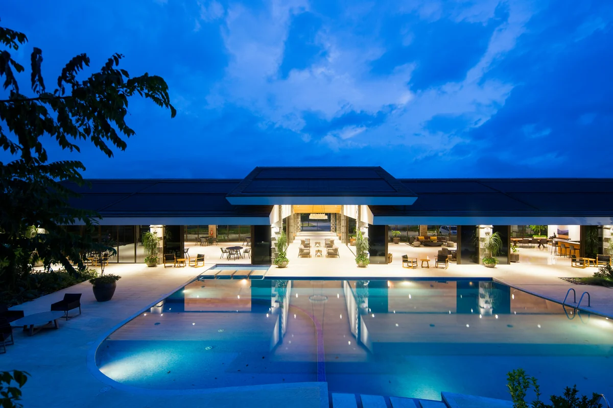 Illuminated luxury villa and swimming pool at dusk